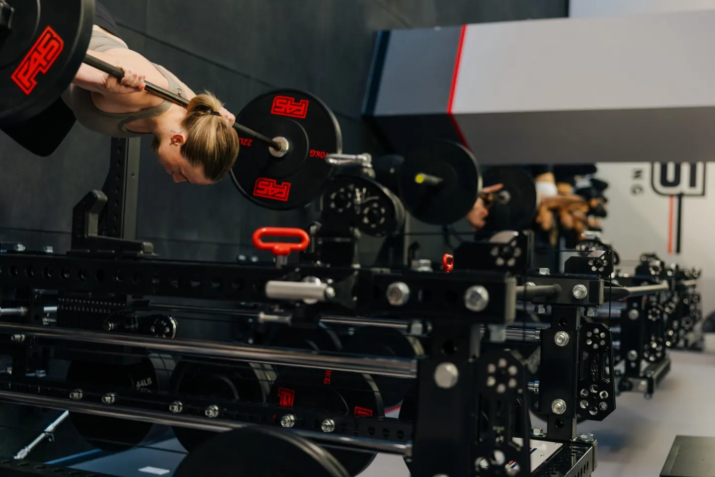 Member lifting a loaded barbell at one of the rig stations during a circuit